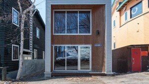 Un edificio moderno de dos pisos con ventanas grandes y fachada de madera.