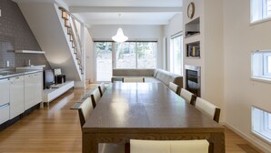 Una cocina moderna con comedor, piso de madera y banco empotrado.