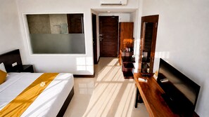 A hotel room with a bed, a desk, a TV, a wardrobe, and a bathroom. - The Visala Boutique Hotel (Keroboken Kelod)