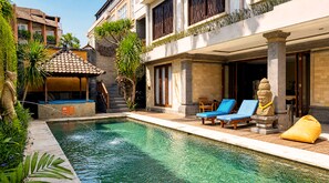 A swimming pool with lounge chairs, a statue, and a covered seating area. - The Visala Boutique Hotel (Keroboken Kelod)