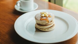 A dessert on a white plate with syrup being poured over it. - The Visala Boutique Hotel (Keroboken Kelod)