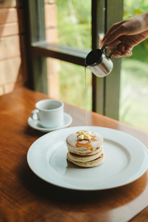A dessert on a white plate with syrup being poured over it. - The Visala Boutique Hotel (Keroboken Kelod)
