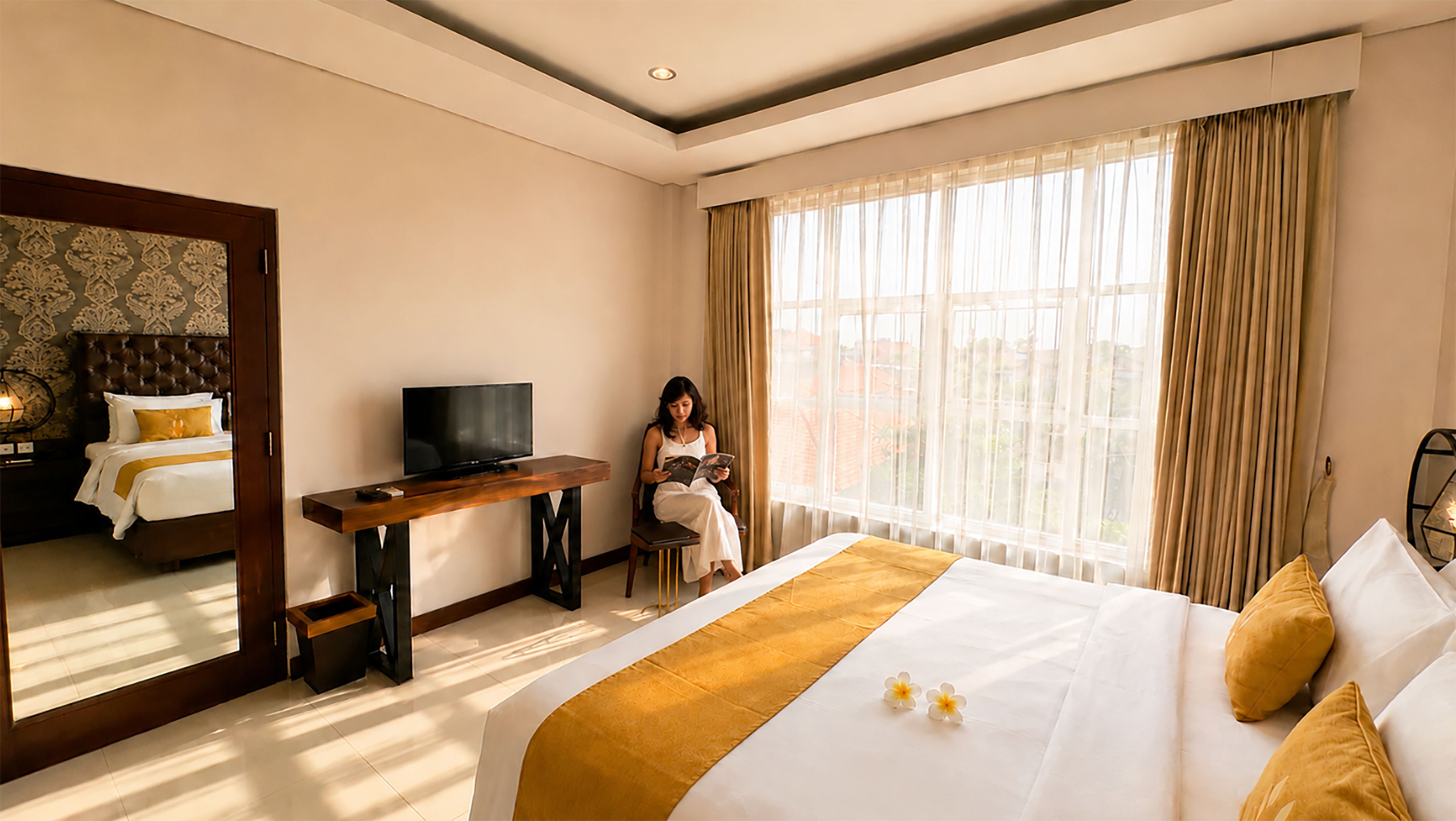 Quarto de hotel com uma cama, televisão, escrivaninha e uma janela grande com cortinas.