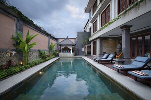 Una piscina al aire libre, sillones reclinables de piscina