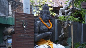A statue of a seated figure with a placard reading "The Visal Boutique Suites." - The Visala Boutique Hotel (Keroboken Kelod)