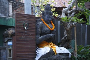 A statue of a seated figure with a placard reading "The Visal Boutique Suites." - The Visala Boutique Hotel (Keroboken Kelod)