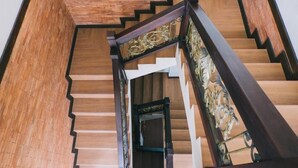 A wooden staircase with a dark handrail and ornate metal balustrade. - The Visala Boutique Hotel (Keroboken Kelod)