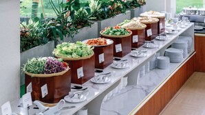 Montaje de bufé con varias estaciones de comida, cada una con un nombre.