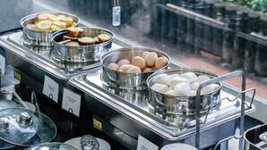 Un bufé con diversos alimentos, incluyendo plátanos, huevos y otros platos.