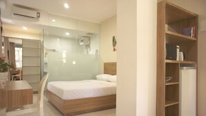 A modern bedroom with a wooden bed, a desk, and a bookshelf. - Menteng House (Jakarta)
