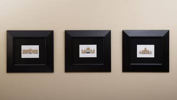 Three framed pictures of a building on a wall.