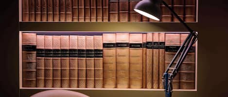 A desk with a lamp and a collection of bookshelves filled with books.