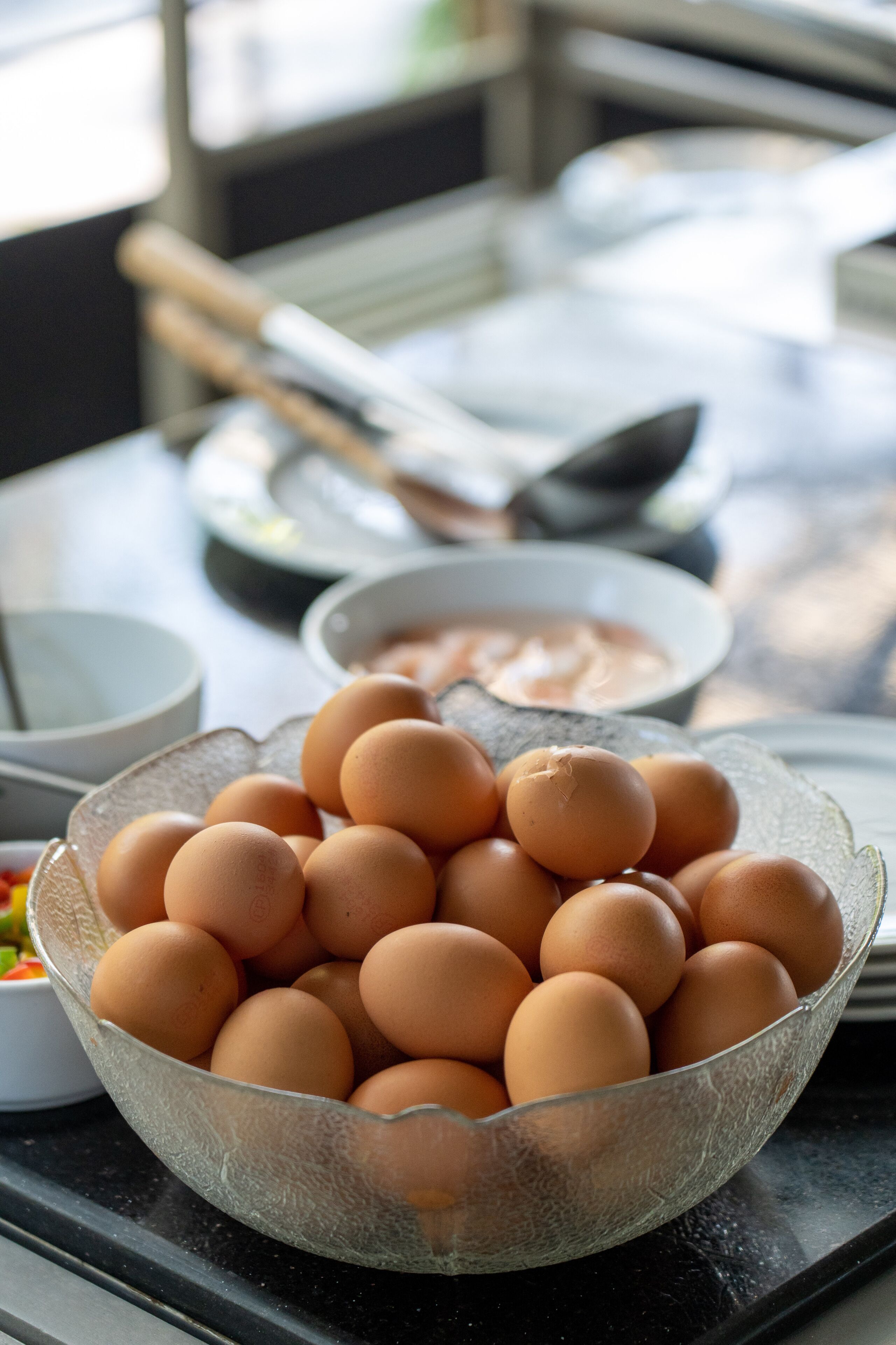 A kitchen counter with a bowl of eggs, a bowl of sauce, and kitchen utensils.