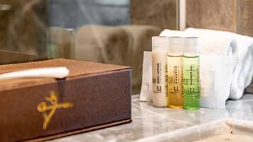 A bathroom with a wooden box, toiletries, and a towel.