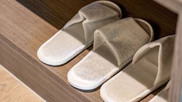 Un par de pantuflas blancas sobre un suelo de madera.