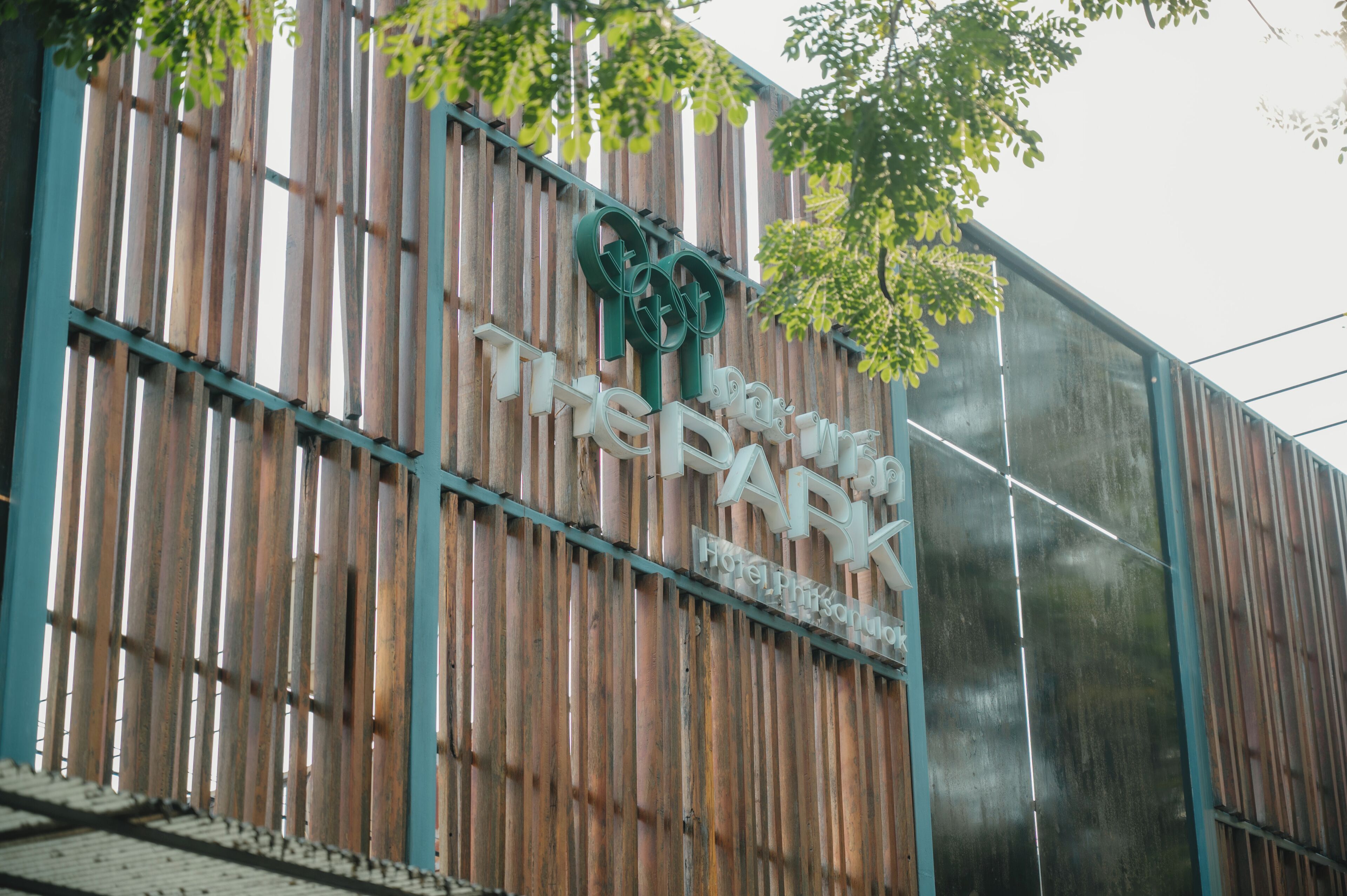A hotel sign with a modern design, featuring vertical wooden slats and a logo.