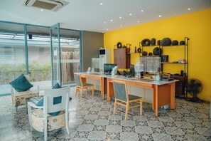 Un espace de bureau moderne comprenant un grand bureau, deux chaises, un ordinateur et un ventilateur.
