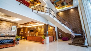 A spacious lobby with a reception desk, a staircase, and a patterned ceiling. - Tjokro Style Yogyakarta (Yogyakarta)