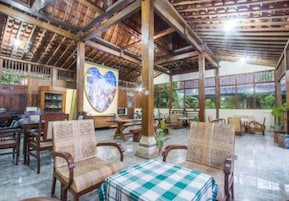 Un espacio interior amplio con muebles de madera, una mesa a cuadros y una gran obra de arte con forma de corazón en la pared.
