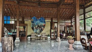 A spacious lobby with a large heart-shaped mural, wooden beams, and a tiled floor. - Mettaloka Guest House and Art Space (Borobudur)