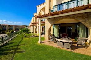 A hotel with a patio area featuring outdoor furniture and a view of the adjacent buildings.