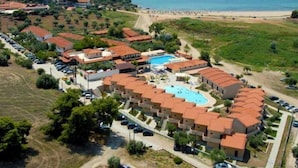 Une vue aérienne d’un complexe hôtelier comprenant plusieurs bâtiments, une piscine et une plage.