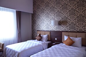 Deluxe kamer | Luxe beddengoed, een kluis op de kamer, individueel gedecoreerd