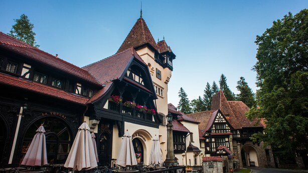Um edifício europeu tradicional com um pátio, com área de estar ao ar livre e um caminho de pedra.