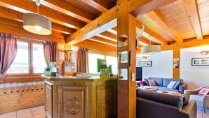 Un interior de madera con una barra central, un sofá y una mesa de comedor.