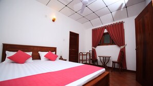 A neatly arranged bedroom with a large bed, a desk, and a chair. - Summer Dew Villa (Unawatuna)