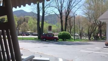Un parking où une voiture rouge est garée près d’un panneau indiquant « Five Star Inn ».