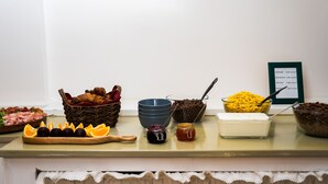 A buffet table with various food items including fruits, pastries, and condiments. - Hotel Arko (Prague)