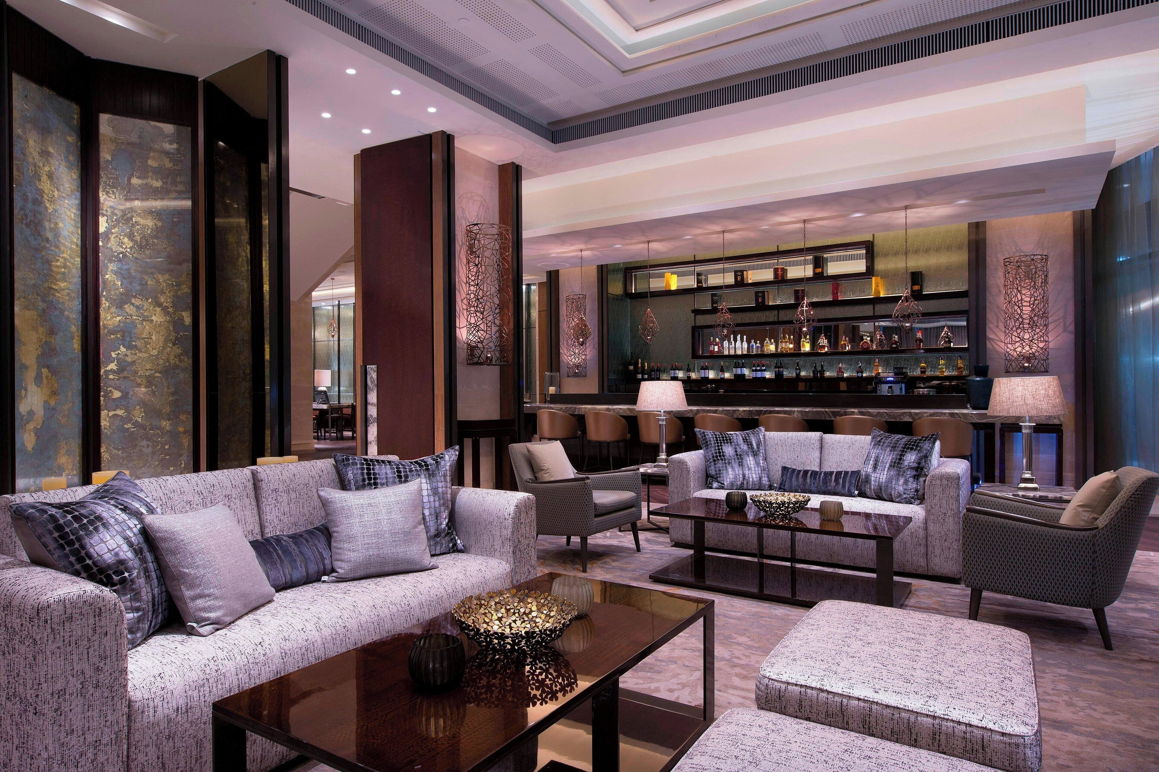 Un área de lounge moderna con sofás, sillones y una barra.