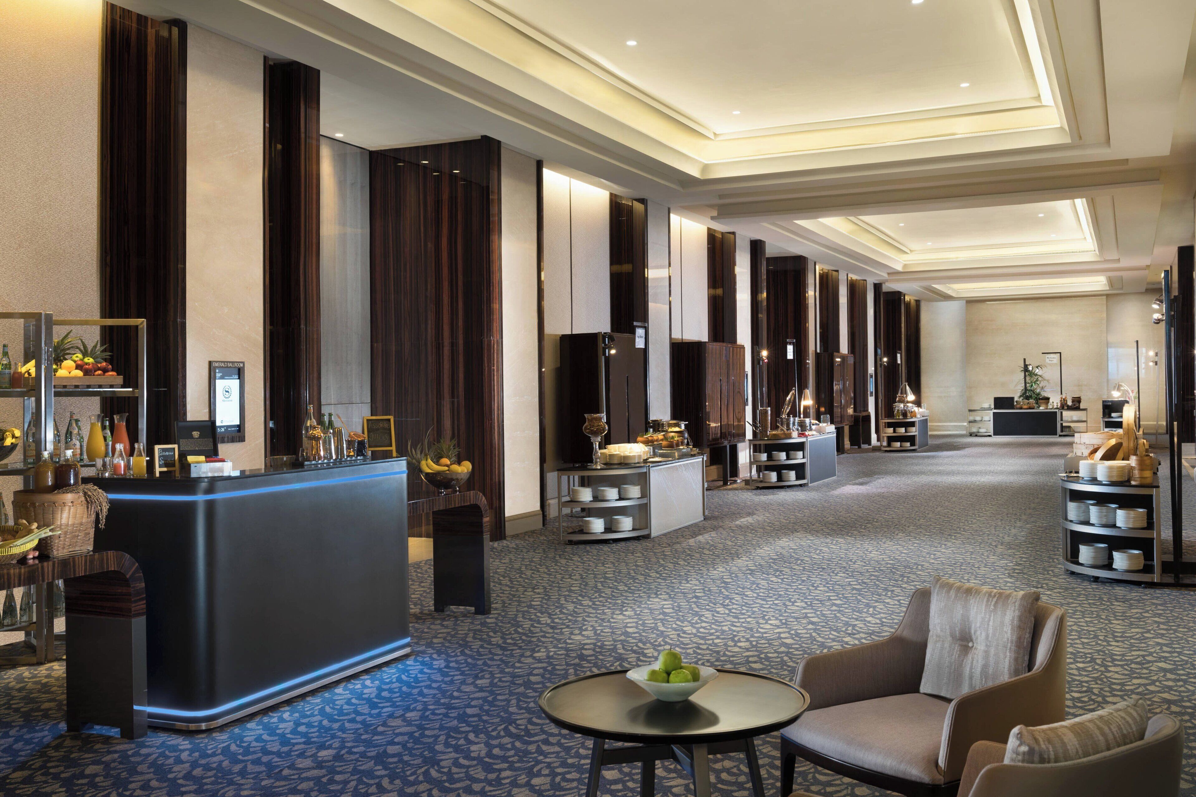 Vestíbulo de hotel con recepción, zona de estar y detalles decorativos.