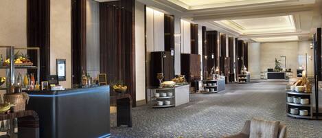 Eine Hotellobby mit Rezeption, Sitzgelegenheiten und dekorativen Elementen.