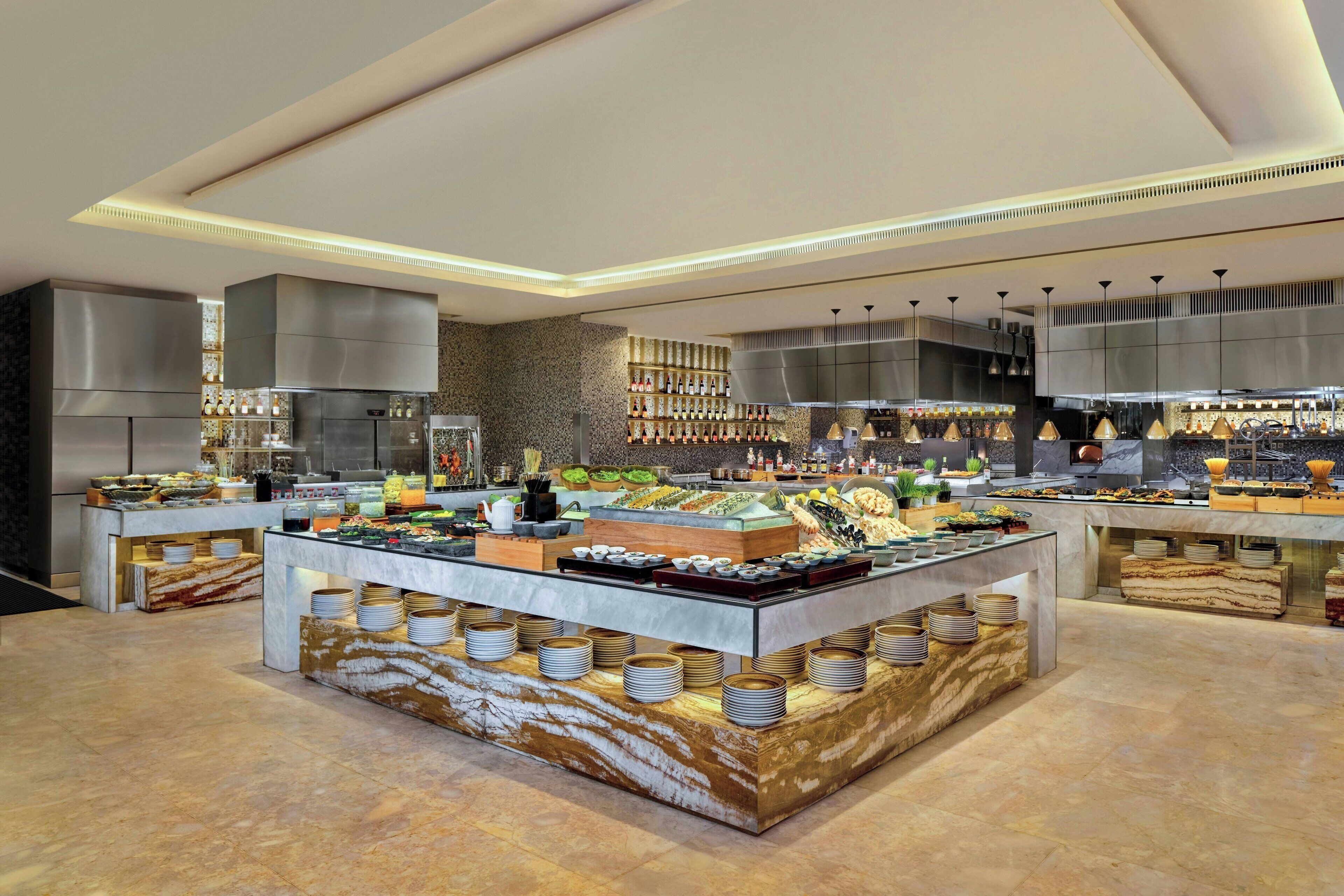 Una presentación de buffet moderna con varias estaciones de servicio, una amplia variedad de alimentos y un diseño limpio y contemporáneo.