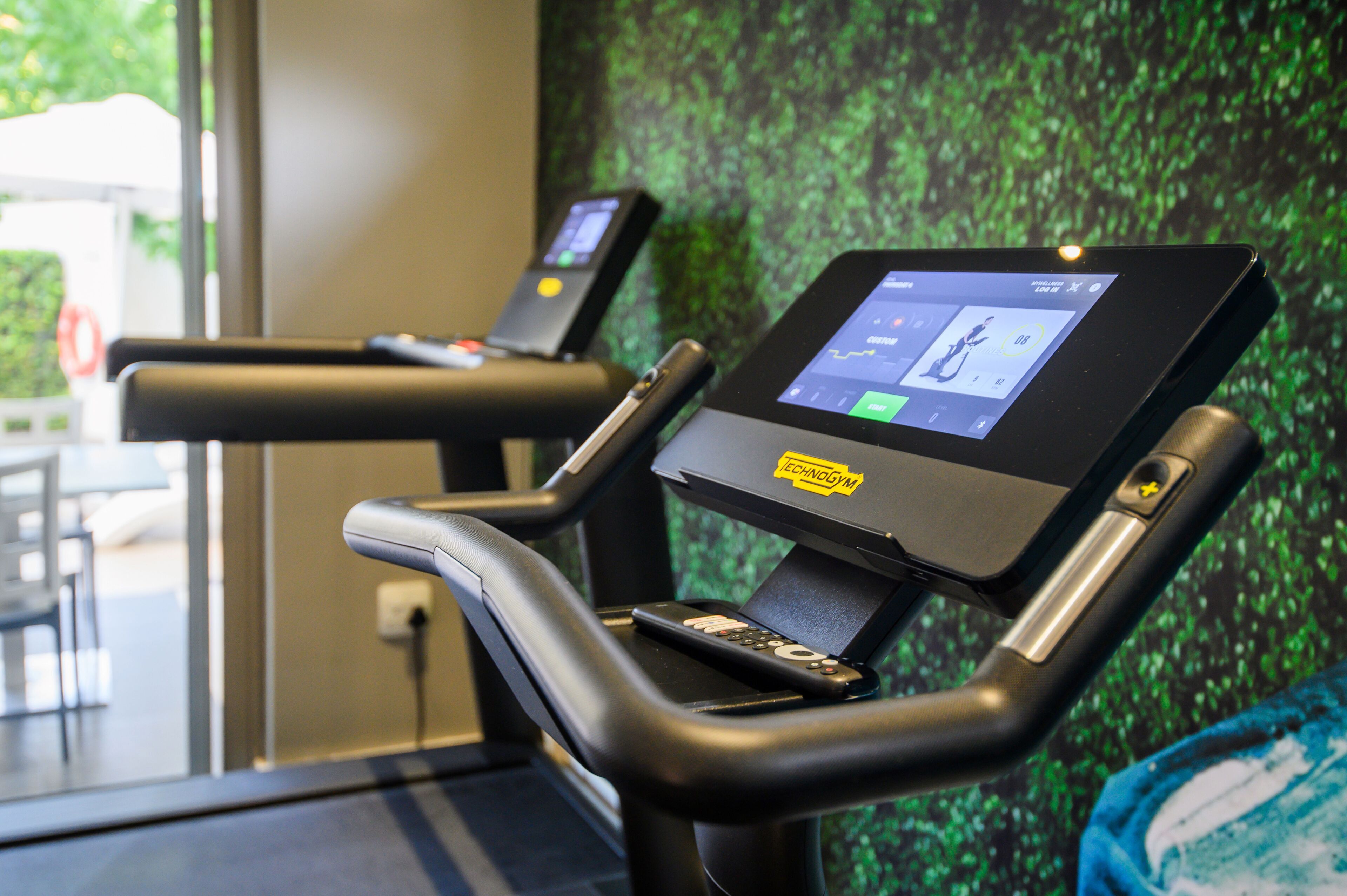 A treadmill with a digital display and a remote control.