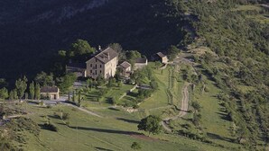 A large, historic building with multiple structures on a hillside, surrounded by lush greenery and terraced fields. - Casa de San Martín (Fiscal)