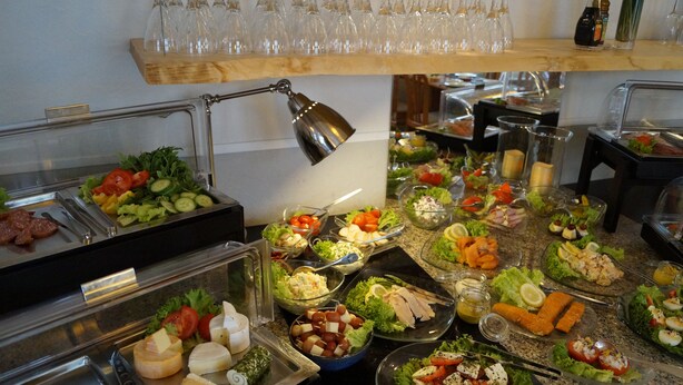 A buffet with various food options including salads, cheeses, and meats. - Hotel Villa Undine (Groemitz)