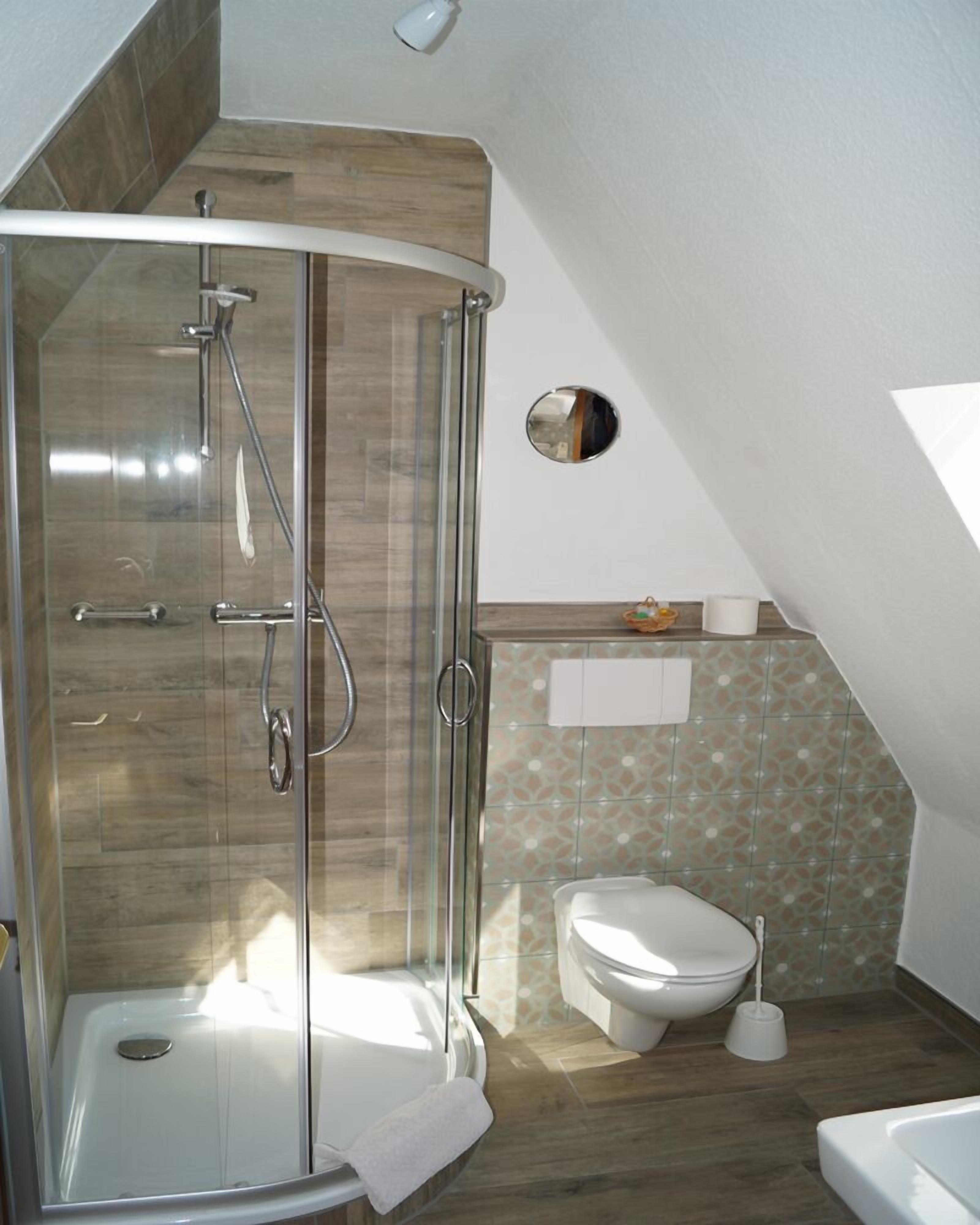 A modern bathroom with a glass-enclosed shower, a toilet, and a bathtub.