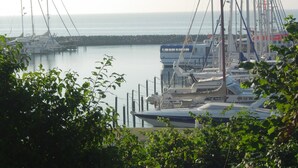 A marina with various boats docked, surrounded by greenery. - Hotel Villa Undine (Groemitz)