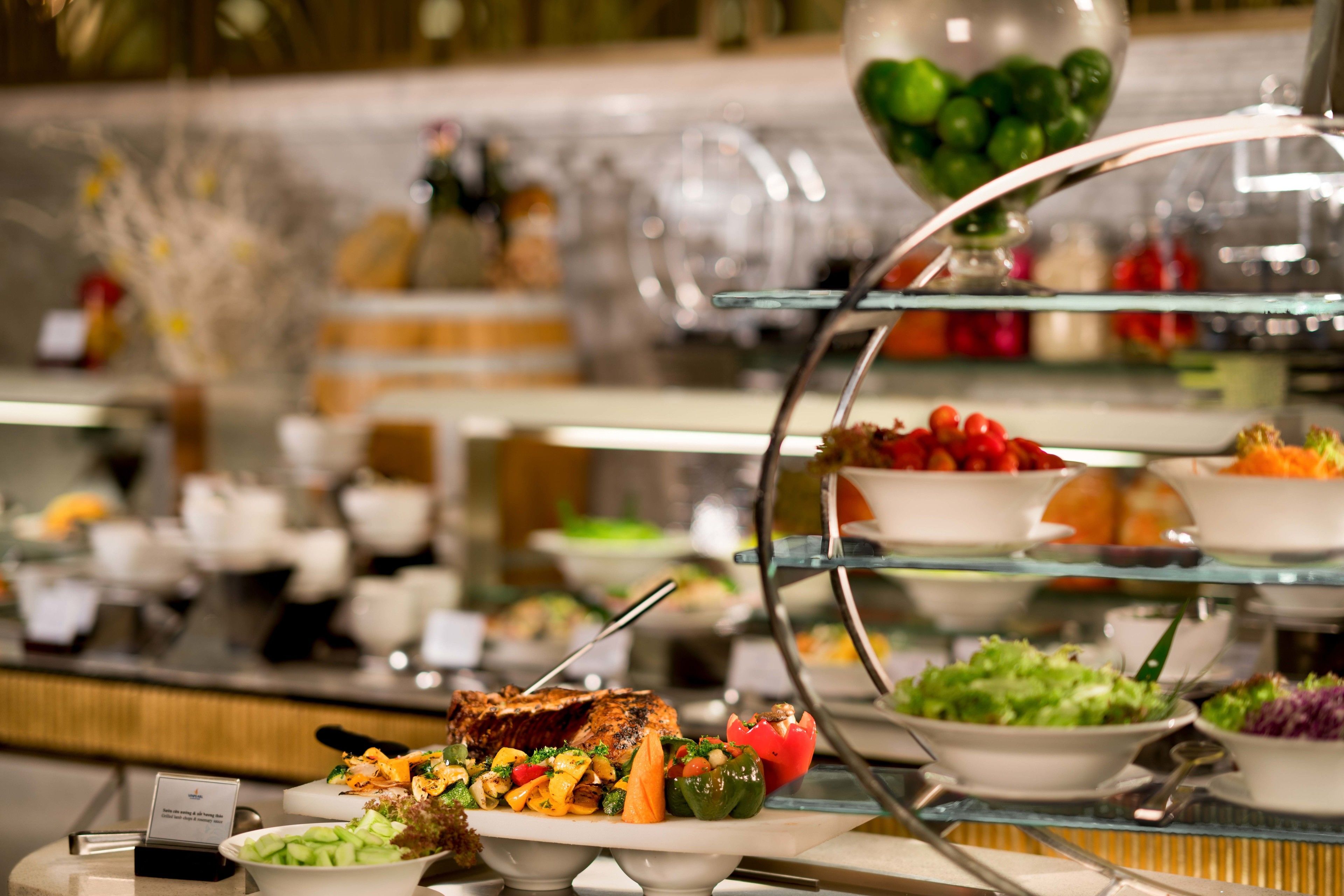 A buffet with various food options including salads, fruits, and a meat dish.