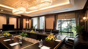A conference room with a long table, chairs, a TV, and a view of the outdoors.