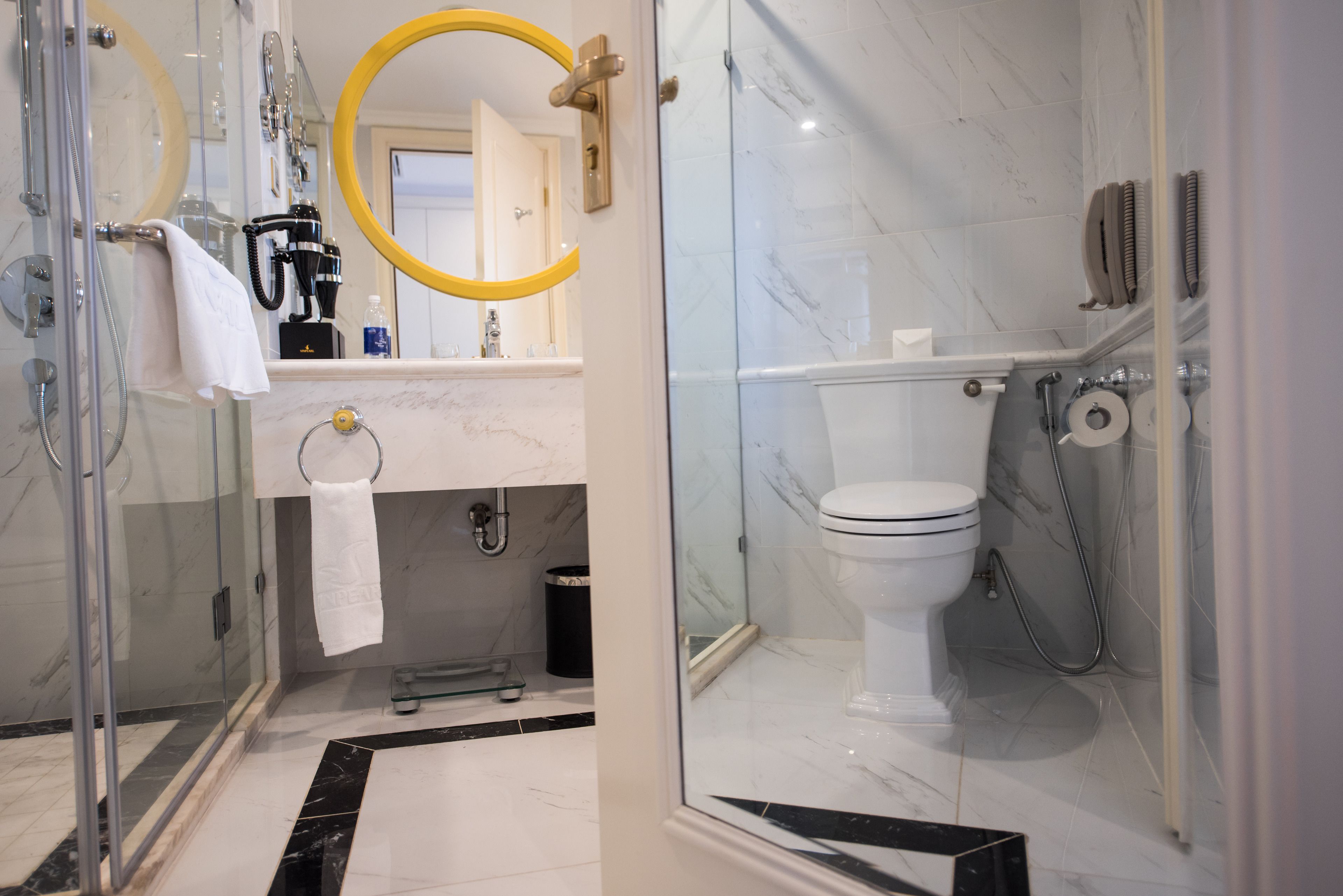 Ein modernes Badezimmer mit Duschkabine aus Glas, Toilette und Waschbecken mit Marmorplatte.