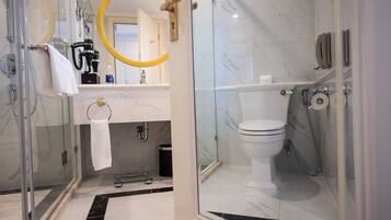 Ein modernes Badezimmer mit Duschkabine aus Glas, Toilette und Waschbecken mit Marmorplatte.