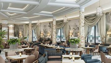 Un amplio vestíbulo de hotel con techos altos, columnas de mármol y cortinas elegantes.