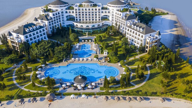 A large resort with multiple buildings, a central pool area, and a beach. - Vinpearl Resort & Spa Ha Long  (Bai Chay)