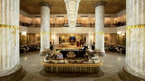 A grand lobby with marble columns, a central bar area, and a chandelier. - Vinpearl Resort & Spa Ha Long  (Bai Chay)
