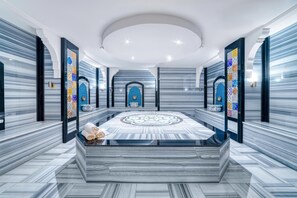 A spacious lobby with a central seating area, a decorative wall with a geometric pattern, and a modern ceiling design. - Hatipoglu Beach Hotel (Alanya)