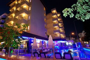A modern hotel with multiple balconies, outdoor seating, and a pool area. - Hatipoglu Beach Hotel (Alanya)